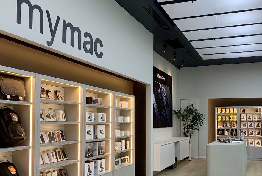 Interior of store showing shelves of Apple tech products and a white service counter.