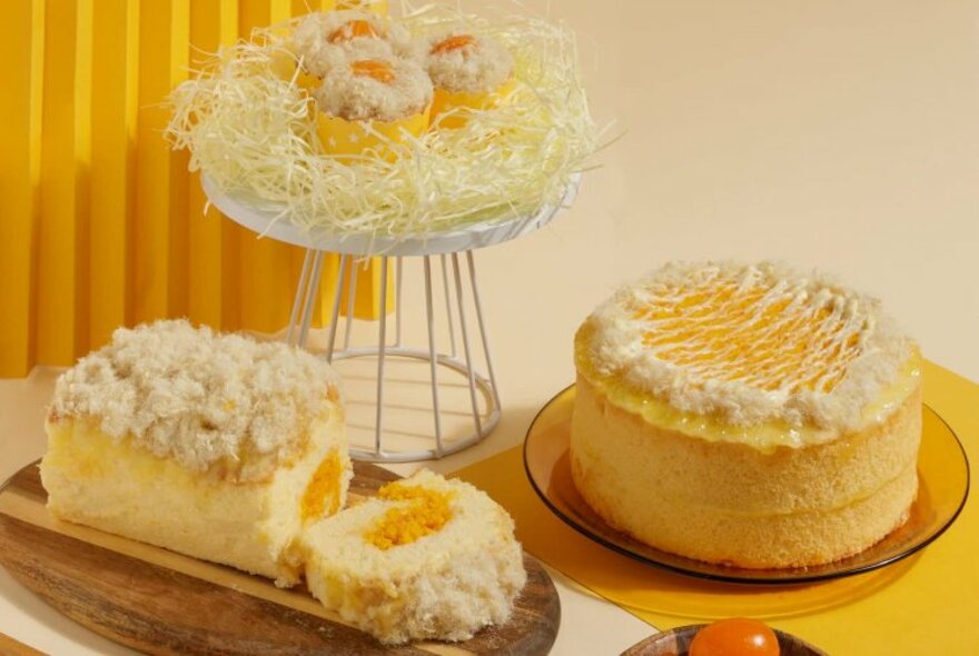 Three salted egg yolk cakes on display, in different shapes and sizes.