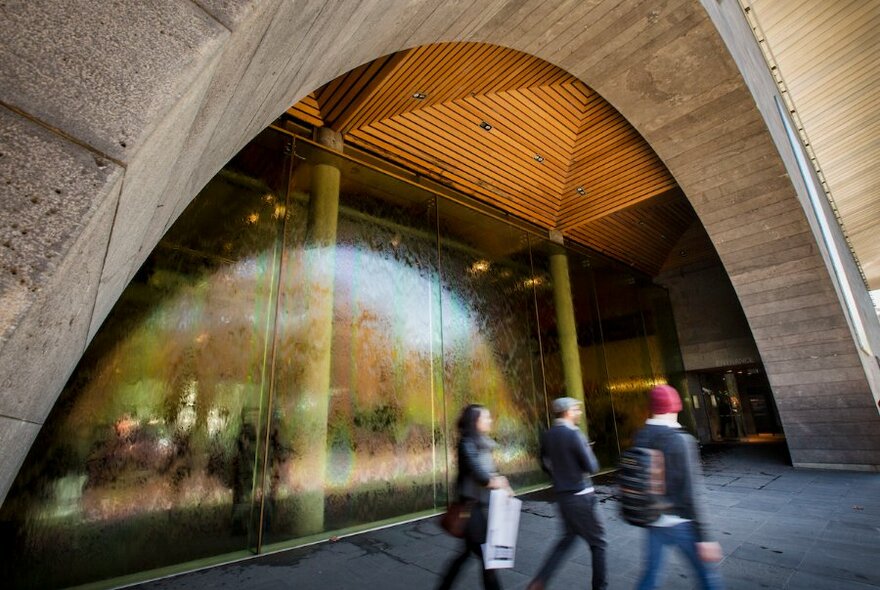 People leaving the NGV, walking past its distinctive water wall.