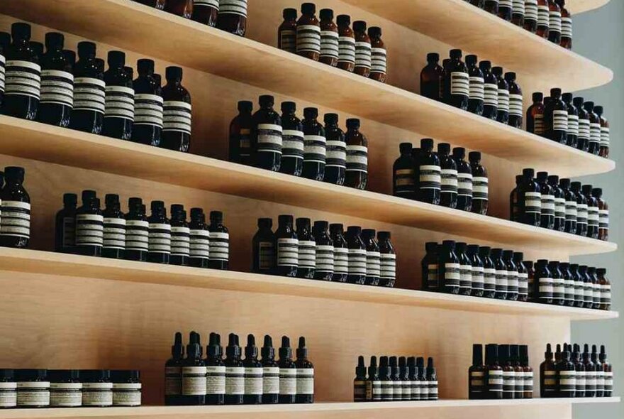 Rows of brown Aesop bottles on shelves at a beauty shop