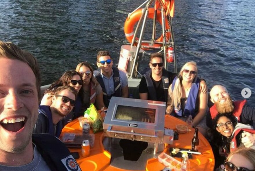 Ten smiling passengers on a round orange boat.