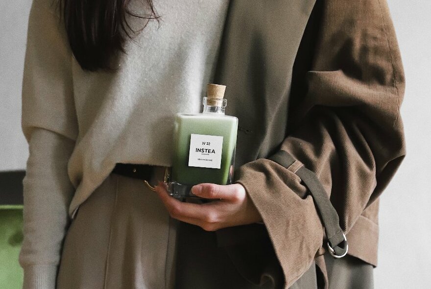 Model with bottle of green tea.