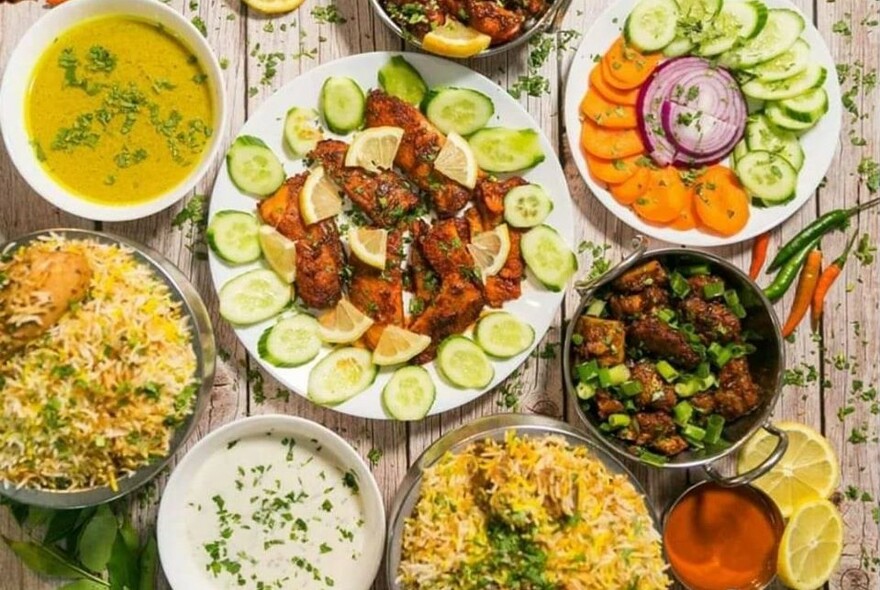A selection of rice, salad and tandoori meat dishes viewed from above.
