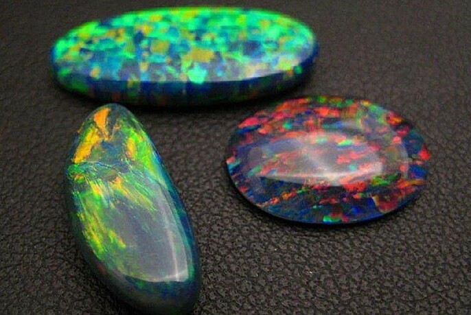 Brightly coloured oval-shaped opals.