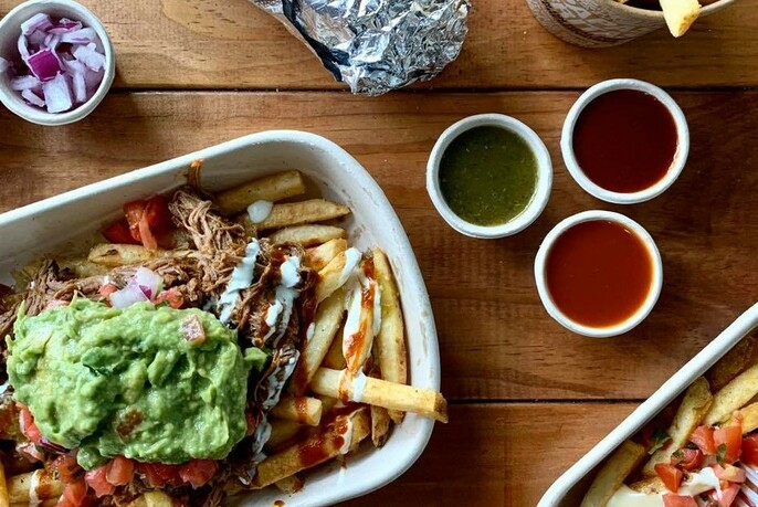 Mexican loaded fries with guacamole and three different sauces. 