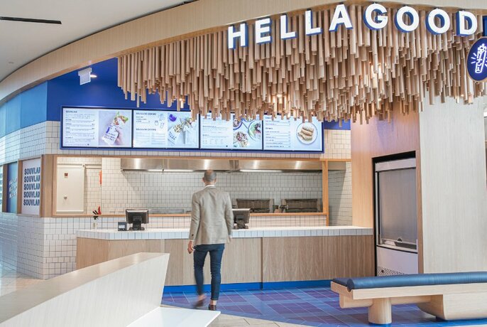 The counter at Hella Good food court restaurant with wooden ceiling detail and bright blue walls and floors