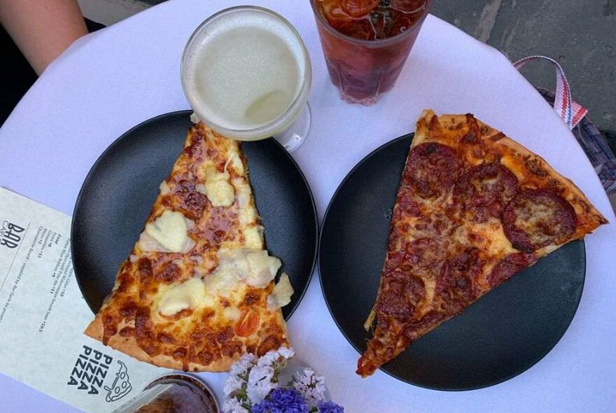 Two pieces of pizza on black plates