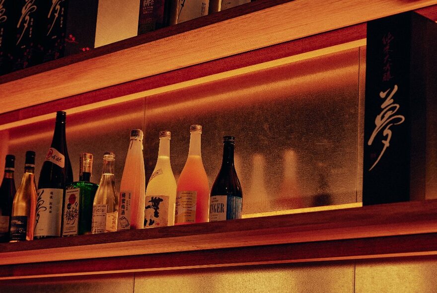 Sake and plum wine on a shelf in a Japanese restaurant.