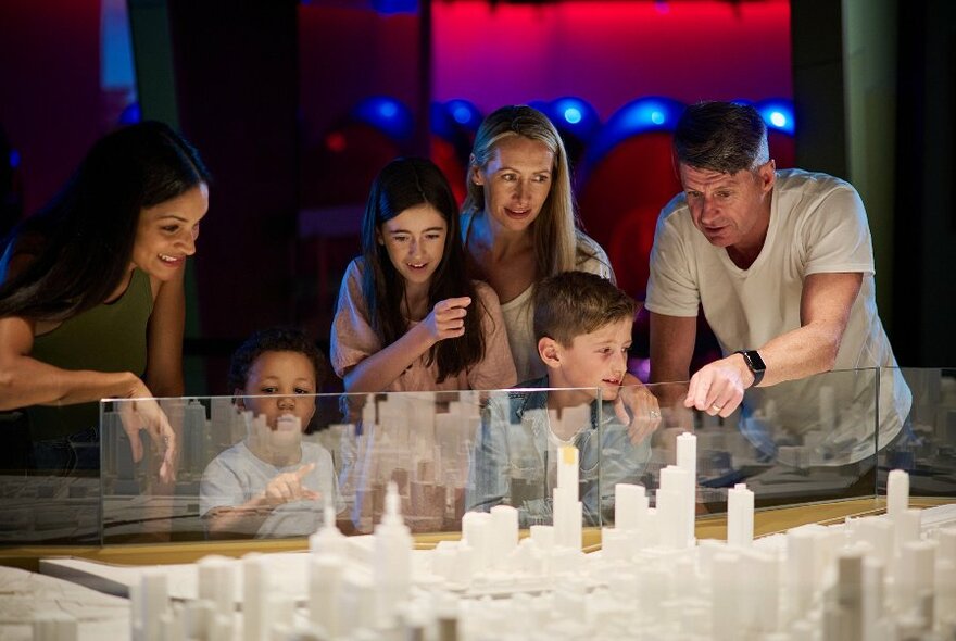 Families looking at a three dimensional small scale model of Melbourne city.
