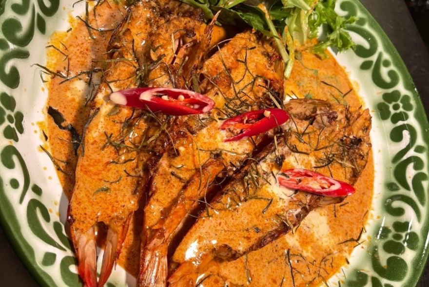 Prawns in a spicy sauce, garnished with red chilli and coriander leaves.
