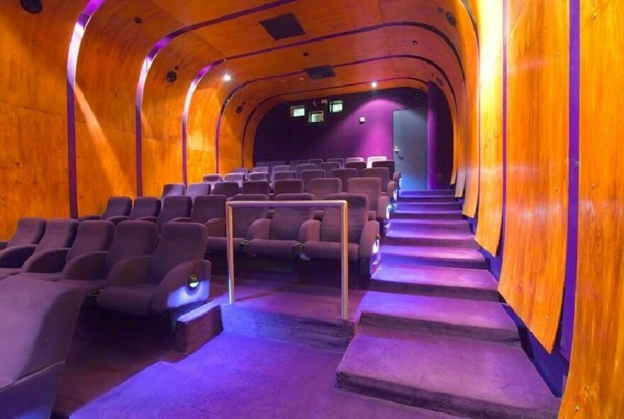 Purple velour-covered seating in an intimate cinema space.