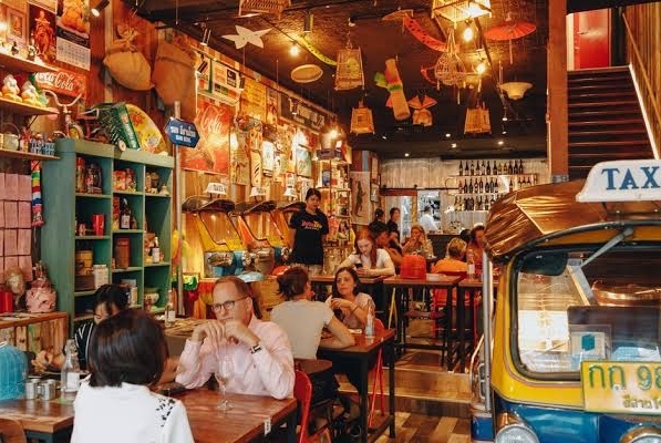 Thai restaurant decorated with old radios and toys, vintage signs and a Tuk-Tuk.