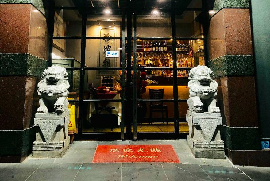 Chinese restaurant entrance with Chinese lion statues either side.