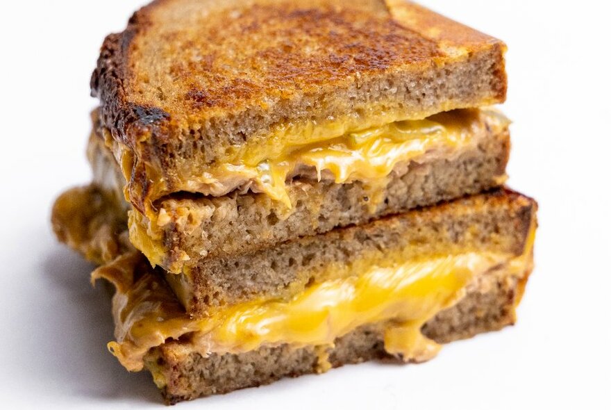 Double toasted sandwich stack with melted cheese oozing out.