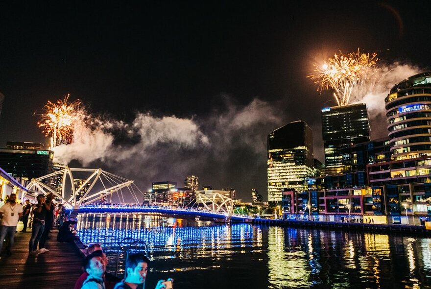 Fireworks and city lights reflected in the Yarra River.