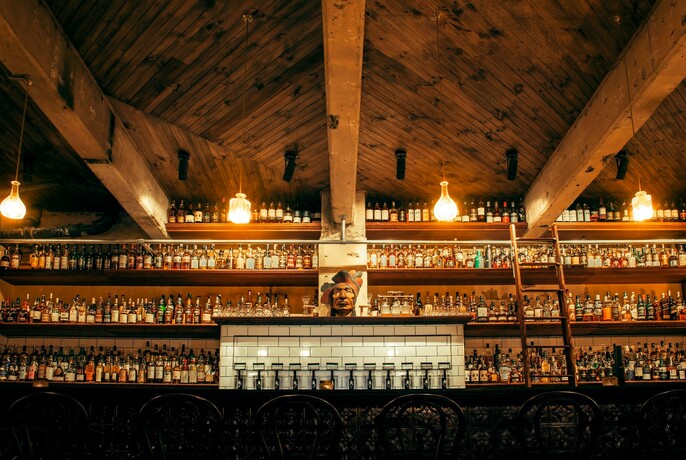 Bar with a very large number of bottles lined up on shelves.