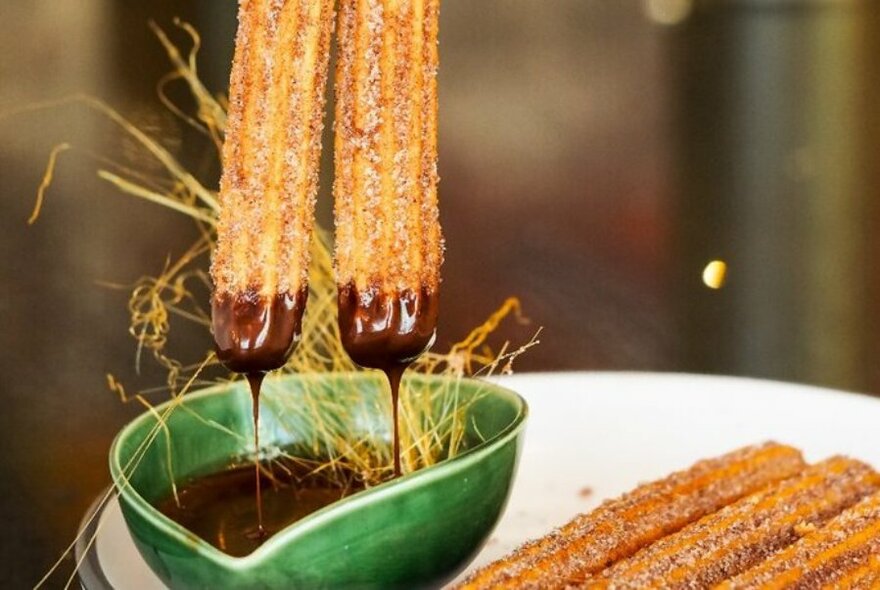 Churros dipped in chocolate.