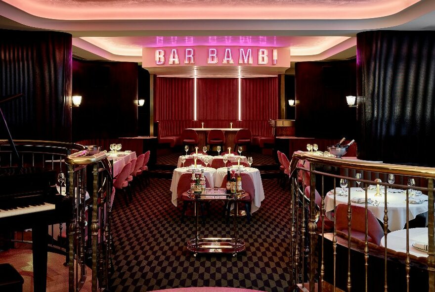 Mezzanine piano bar and main dining room at Bar Bambi, with banquette tables and seating.
