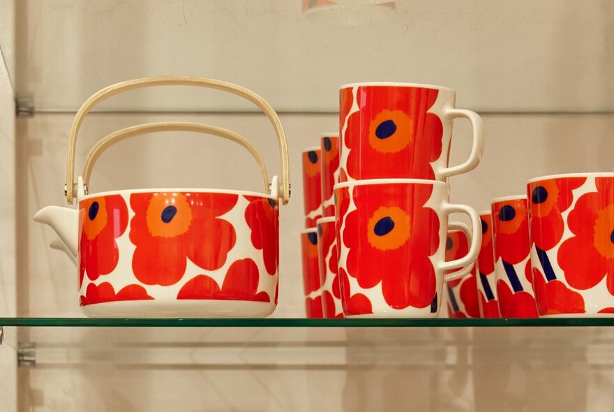 A shop display of Marimekko red poppy mugs and a teapot.