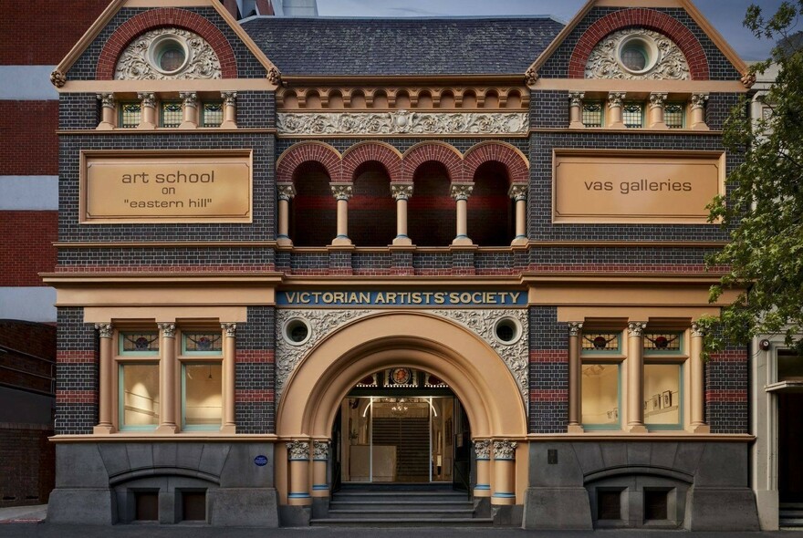 Façade of the 1874 Victorian Artists Society building showing arched entrance, balcony and ornate brickwork.