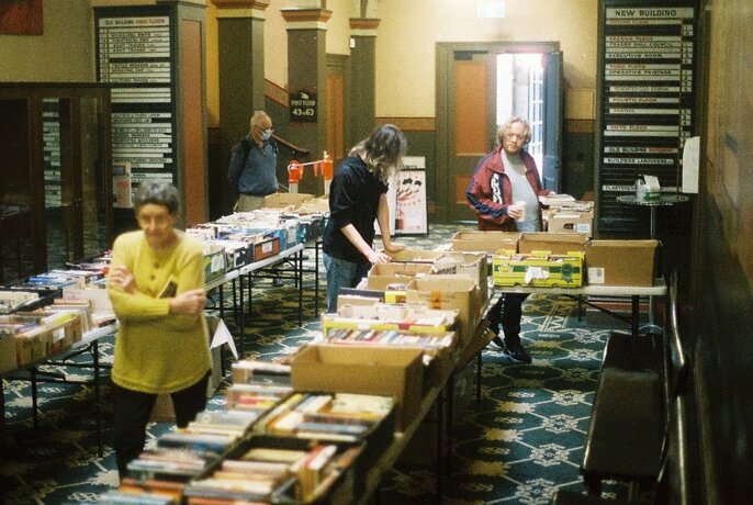 People browsing tables of books.