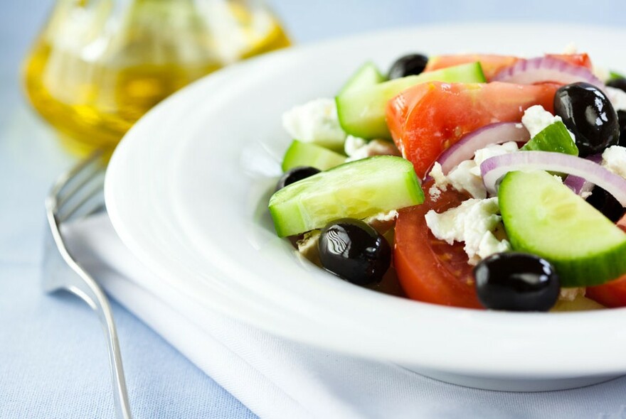 A white bowl of Greek salad.