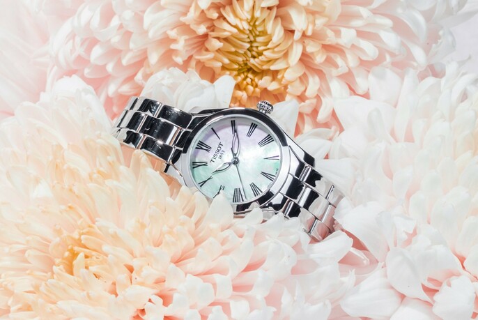 A wristwatch lying in chrysanthemum flowers.
