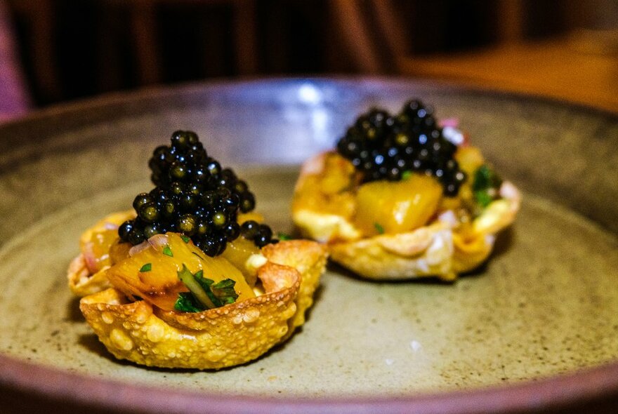 Two canapes with pineapple and caviar