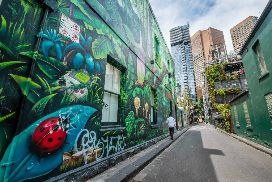 Mike Makatron's Jungle Funk Mural in Meyers Place, featuring a ladybug on a leaf in the foreground.