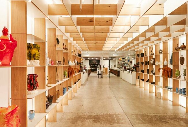A light-filled arts and crafts shop with wooden display shelves 