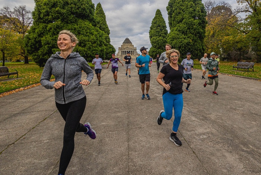 A group of runners on a path with Melbourne's Shrine of Remembrance in the background. 