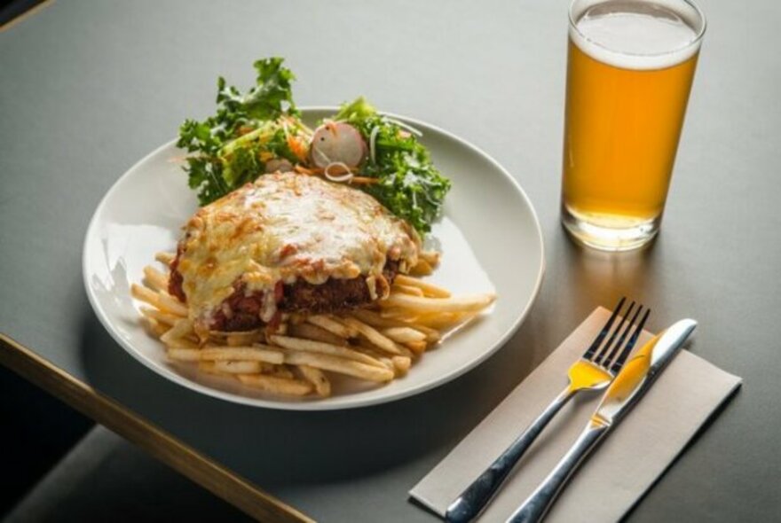 Chicken parmigiana and glass of a beer.