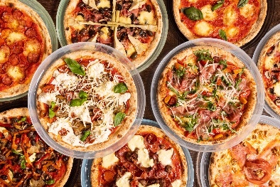 Several pizzas with a range of toppings.