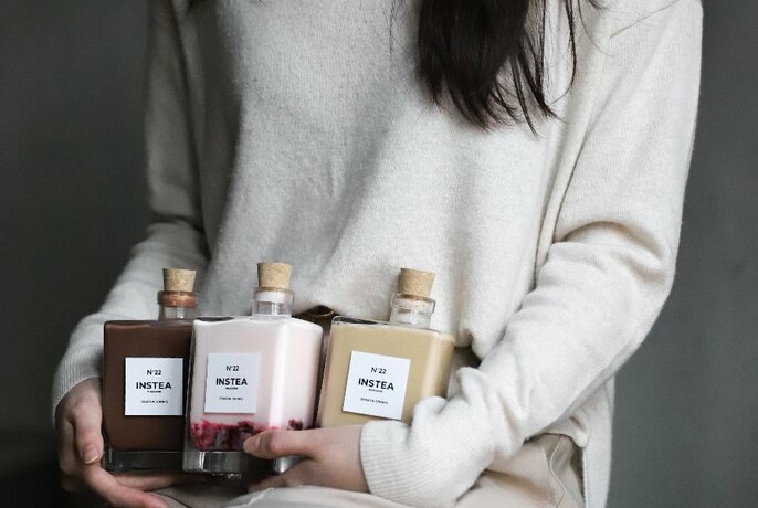 Model with three bottles of INSTEA products.