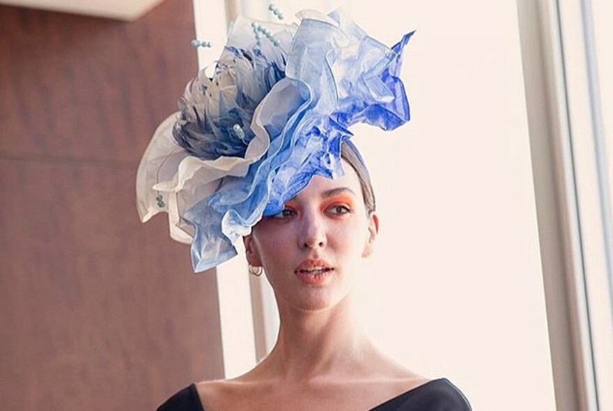 Model wearing a blue and white chiffon flower headpiece.