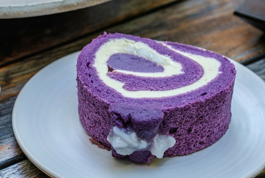 A purple sponge cake roll with cream.