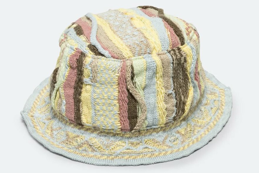 A knitted bucket hat with different coloured stripes and textures.