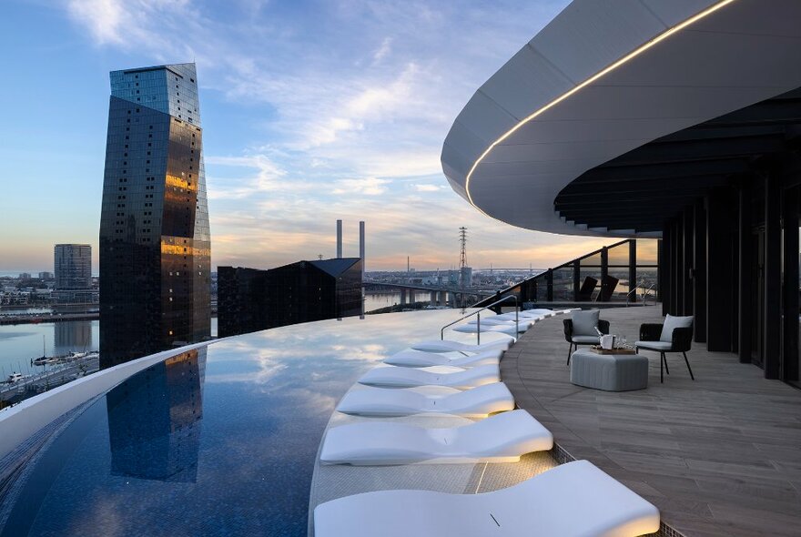 A rooftop infinity pool with city buildings in the background.
