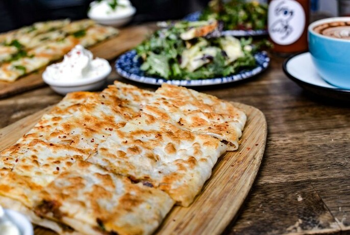 A plate of gözleme served with salad and coffee.