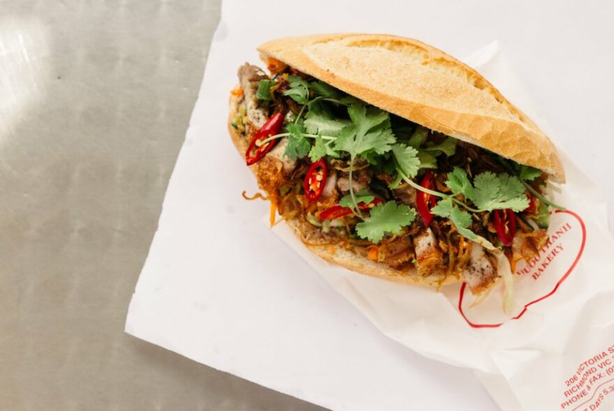 Vietnamese banh mi roll with meat, salad and chilli.