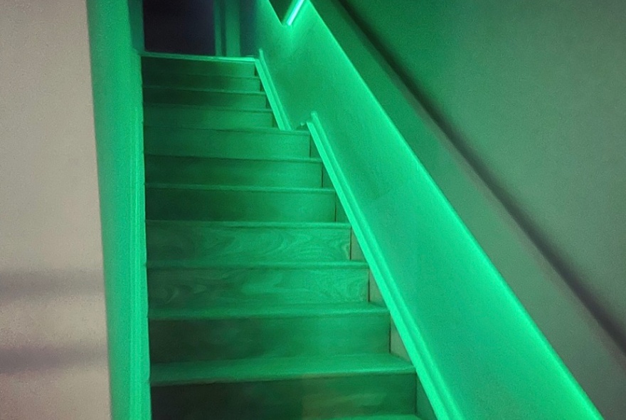 A stairway lit in a soft green light.
