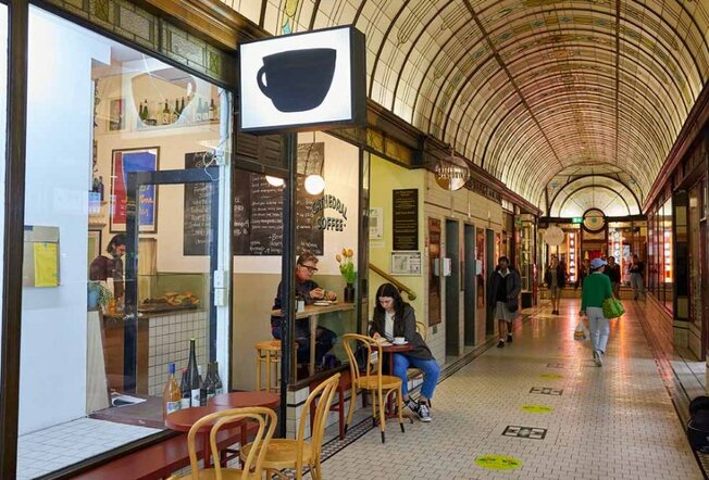A small coffee shop in a decorated arcade.