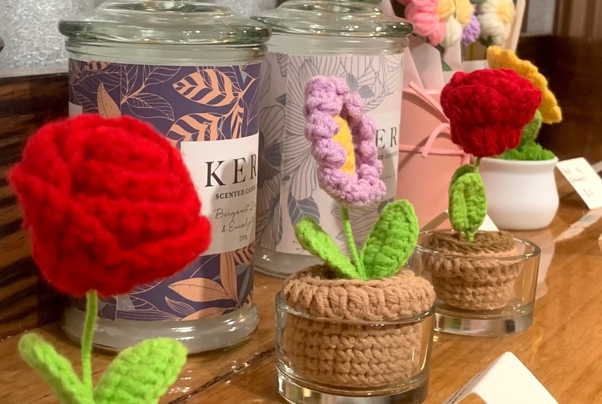 Crocheted flowers in crochet pots, being sold as gifts in a flower shop.