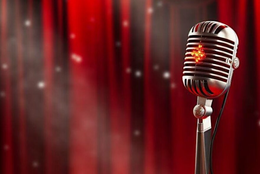 Microphone in front of red curtains.