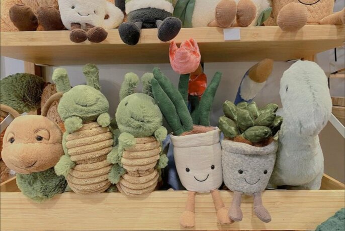 A collection of stuffed toys on a shelf 