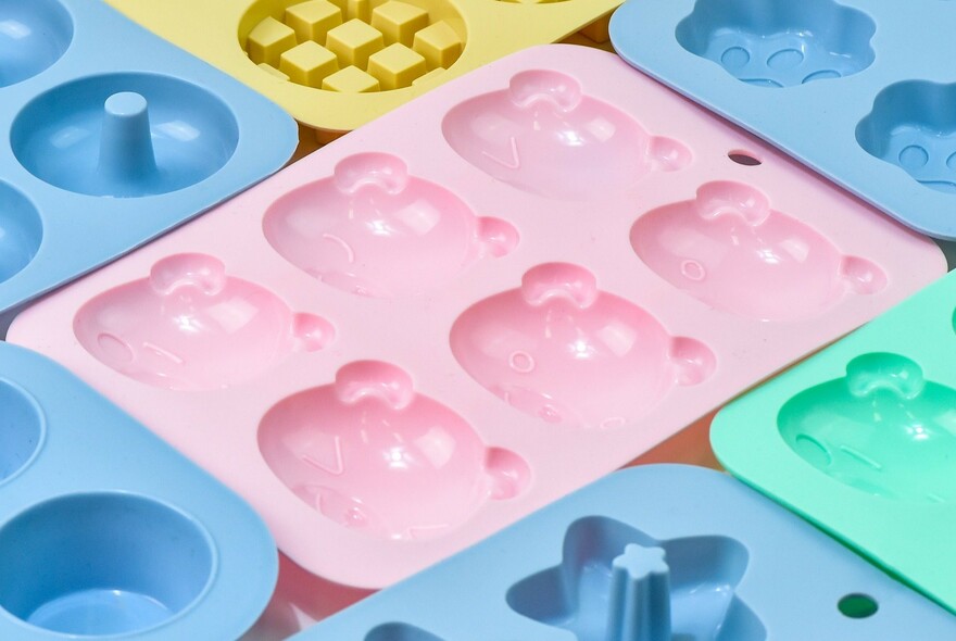 Coloured plastic moulds in shape of teddy bear heads.