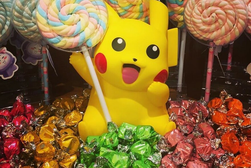 Pikachu surrounded by lollies and lollipops.