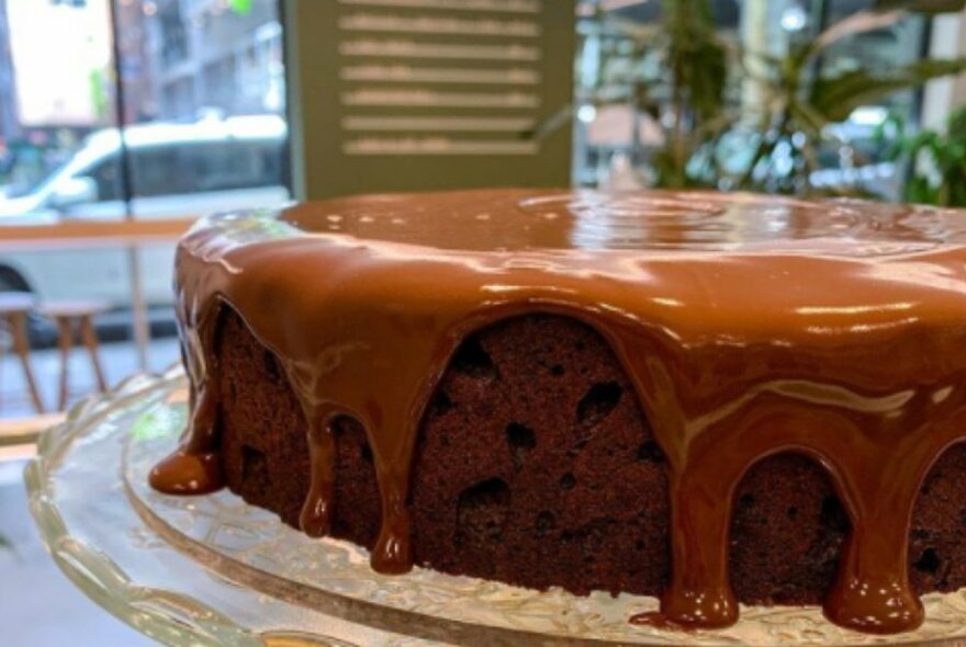 A chocolate cake with icing drizzled over top. 
