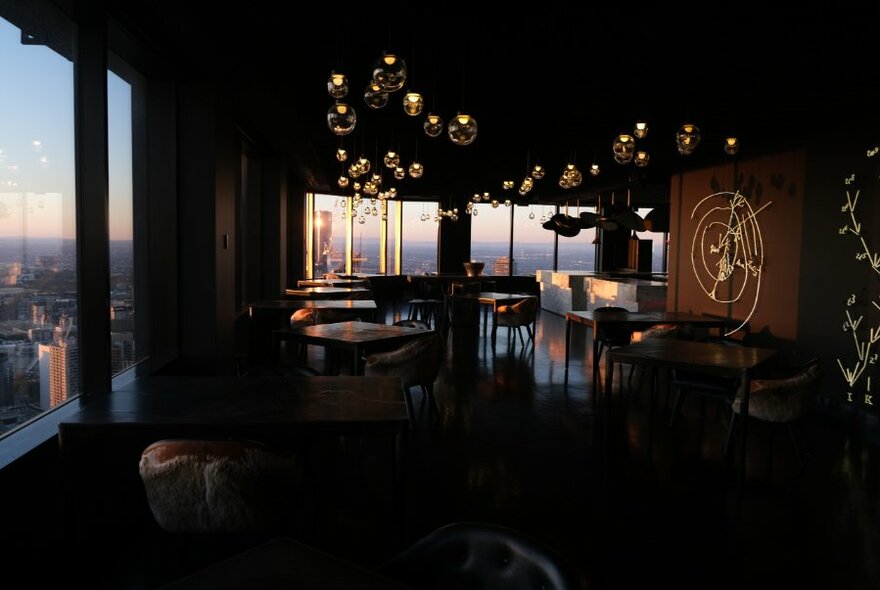 Dimly-lit restaurant with sweeping views of the city.