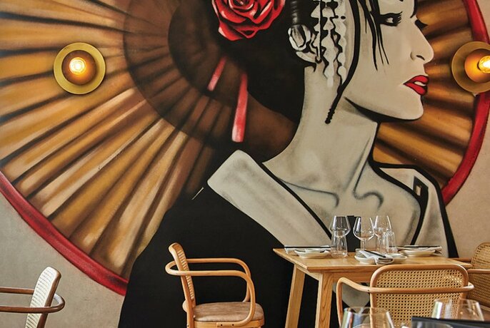 A restaurant with a giant Geisha mural. 